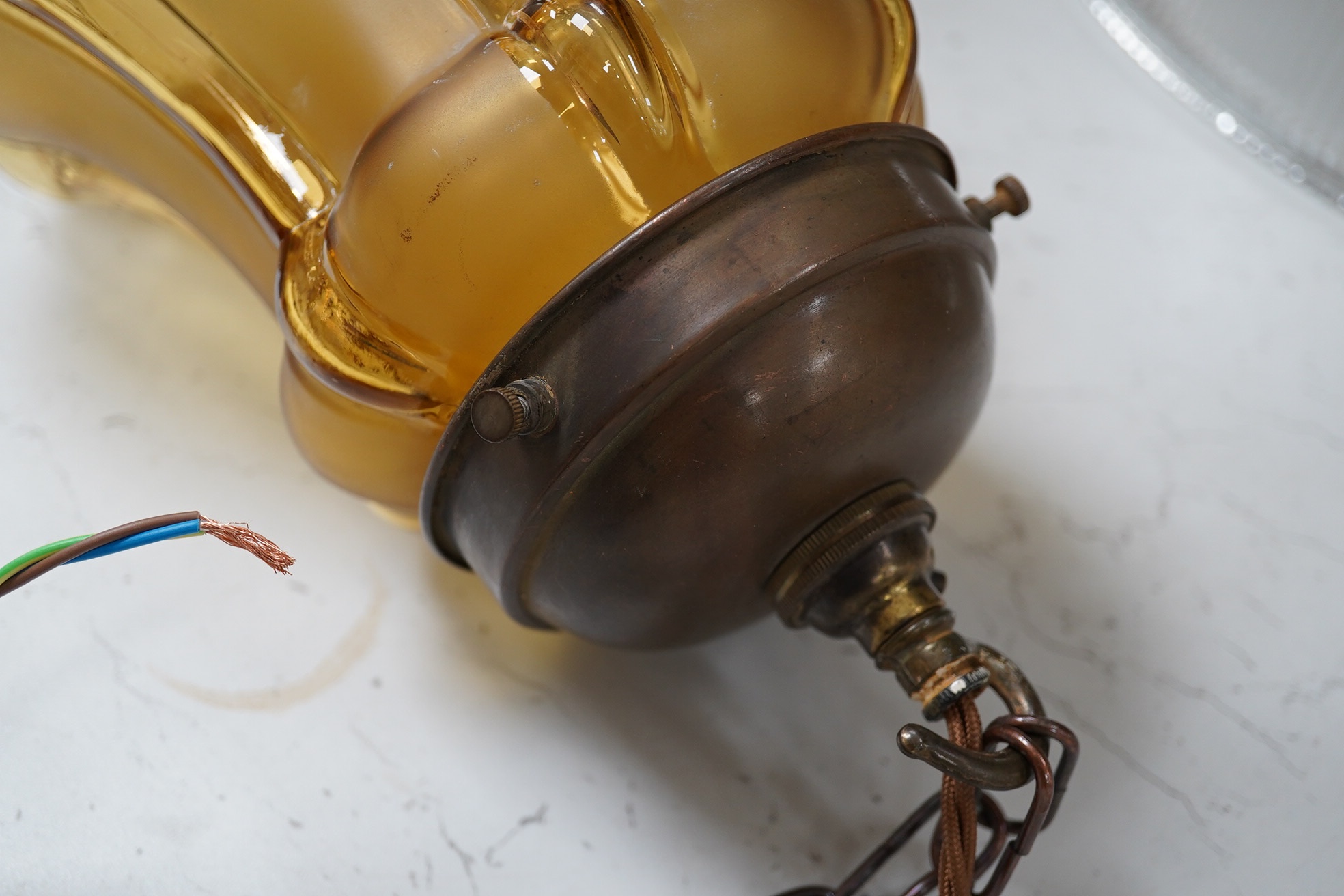 A large English amber colour glass pendant with original antique brass fitting, chain and ceiling rose, circa 1930, wired, 33cm high to top of gallery, 18cm wide. Condition - good